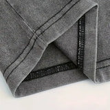 Close-up of grey ribbed fabric with double-stitched hem, highlighting garment quality.
